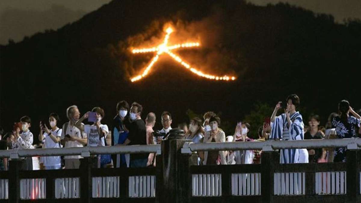 Erleben Sie die beeindruckende Tradition von Gozan no Okuribi in Kyoto, Japan, mit riesigen Freudenfeuern auf den umliegenden Bergen, die das Ende des Obon-Festes feiern. Erleben Sie die beeindruckende Tradition von Gozan no Okuribi in Kyoto, Japan, mit riesigen Freudenfeuern auf den umliegenden Bergen, die das Ende des Obon-Festes feiern.