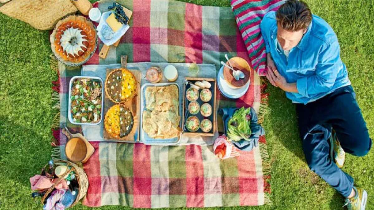 Feiern Sie den Internationalen Picknick-Tag in Stil und genießen Sie die freie Natur, während Sie unter einem Baum auf einer Decke sitzen und köstliche belegte Brote genießen.